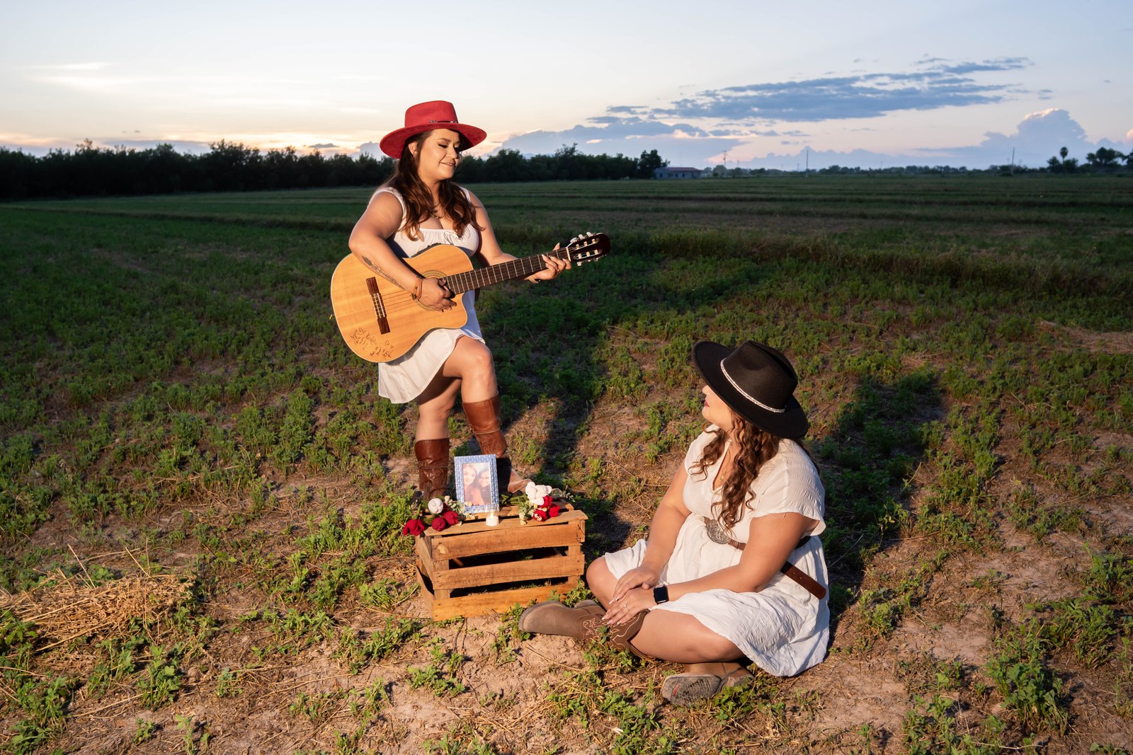 Karina y Yazmín cantando junto a una guitarra al atardecer