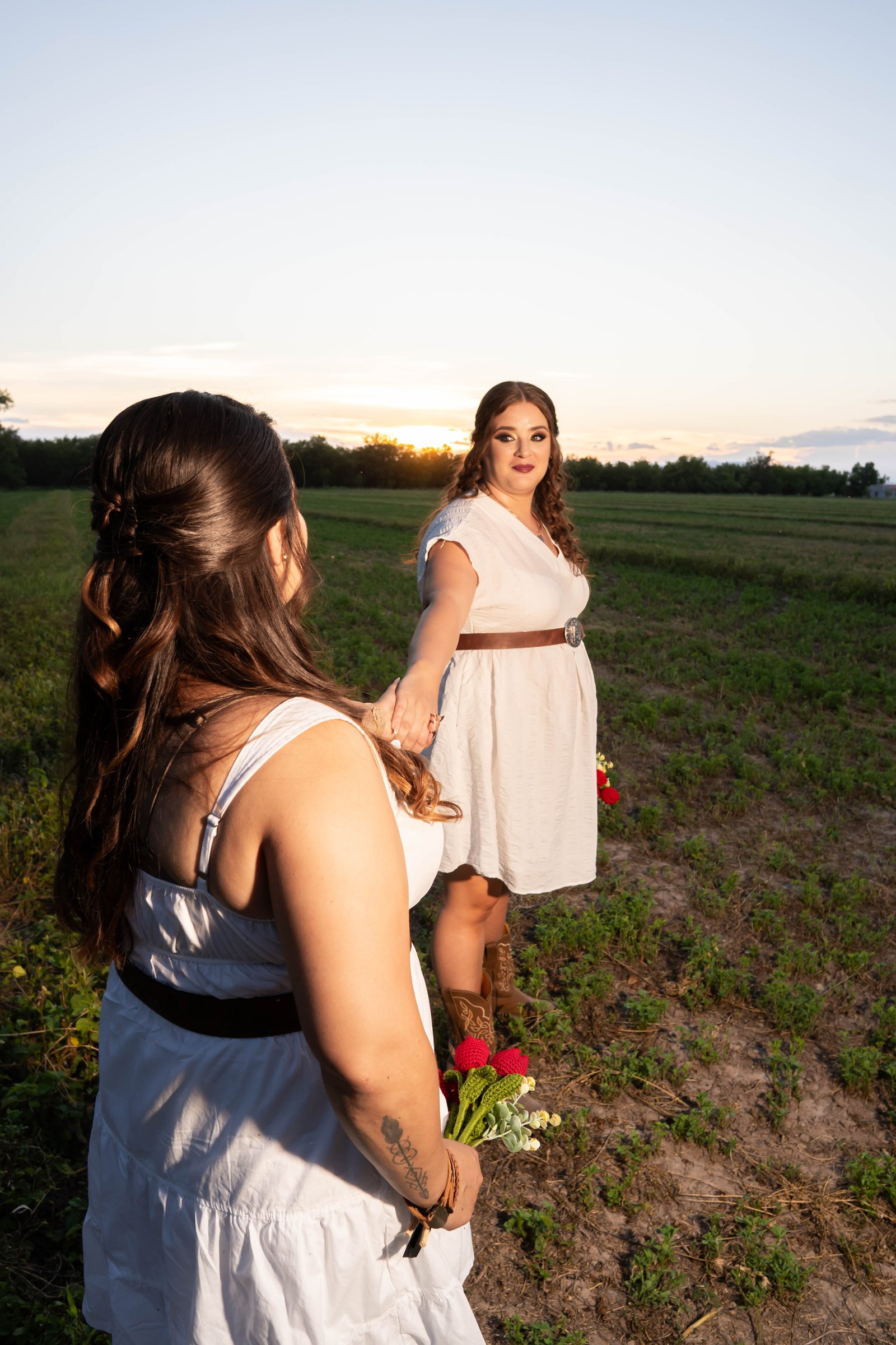 Yazmín tomando la mano de Karina en el campo